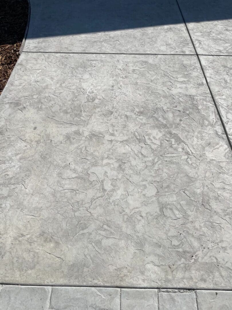 Textured concrete sidewalk under sunlight.