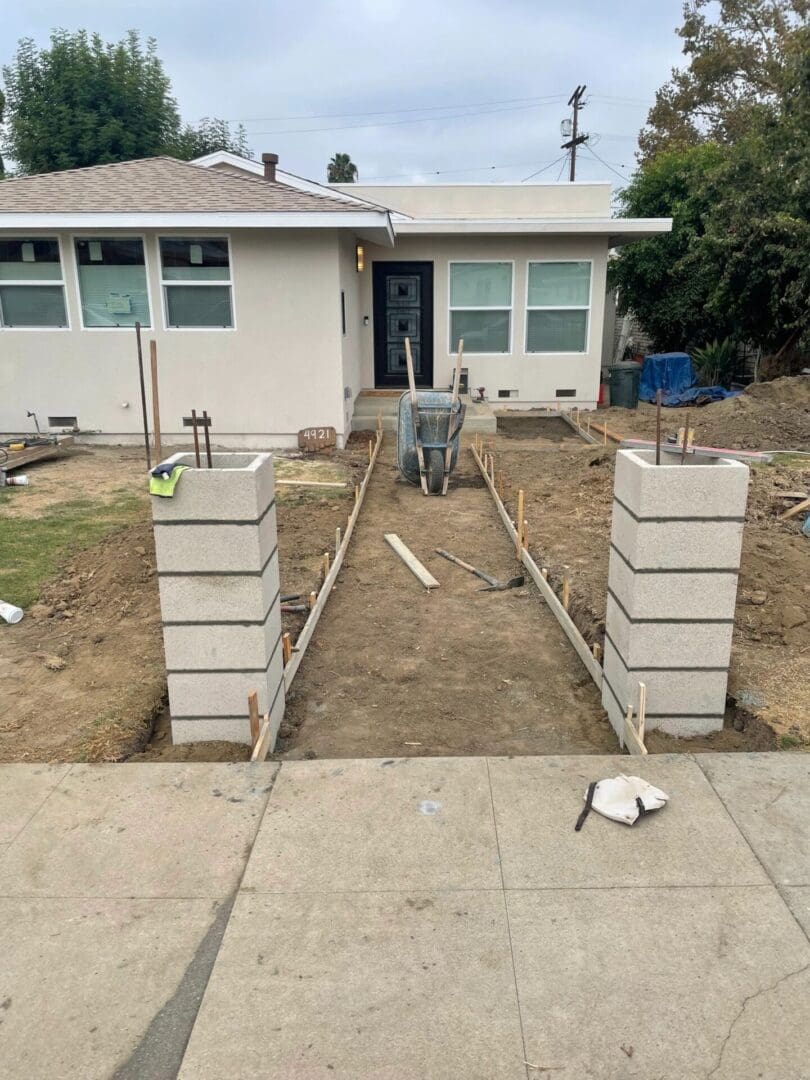 House entrance under construction with concrete pathway.