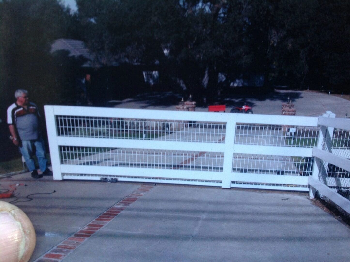 Man standing next to a white gate.