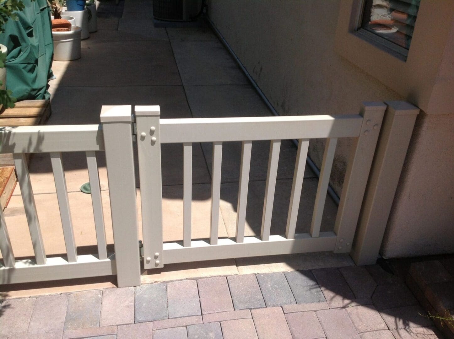 White wooden gate on a paved pathway.