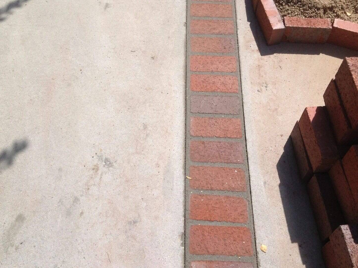 Red brick border on concrete pavement.
