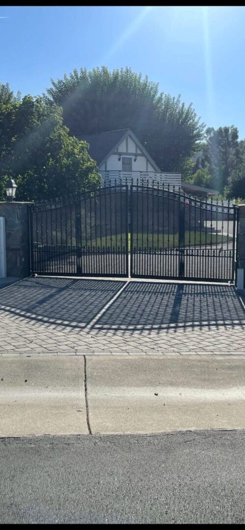 Gated driveway entrance with house behind.