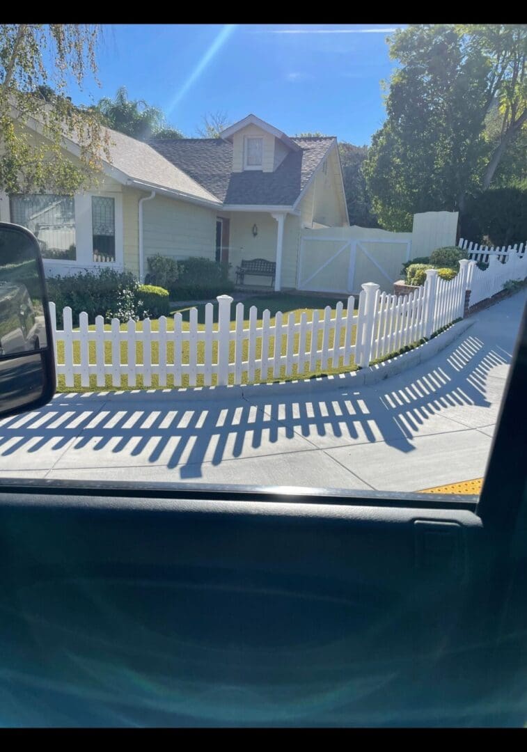 House with white picket fence and shadows.
