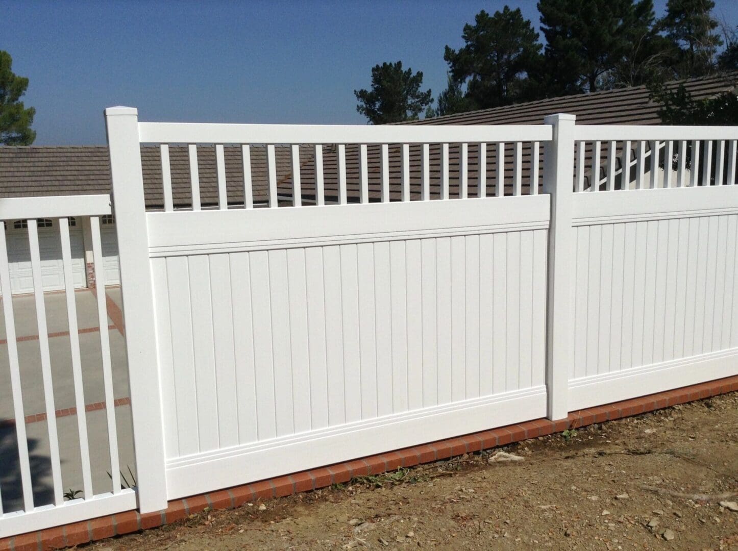 White vinyl fence with vertical slats.