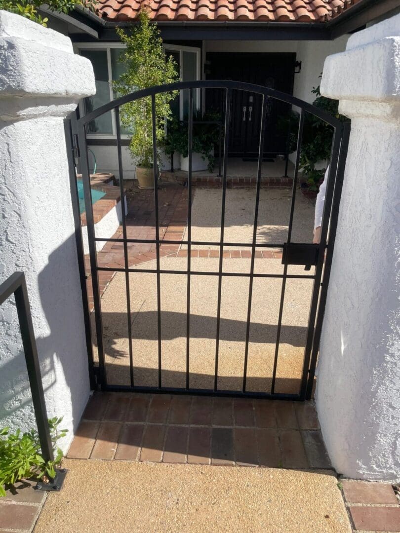 Black metal gate leading to house entrance.