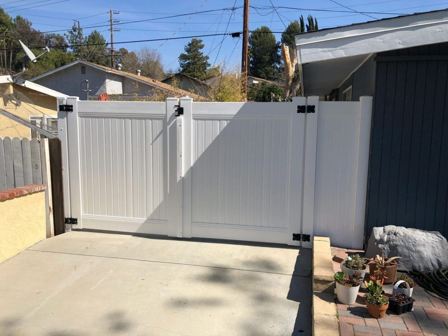 White gate with garden and driveway view.