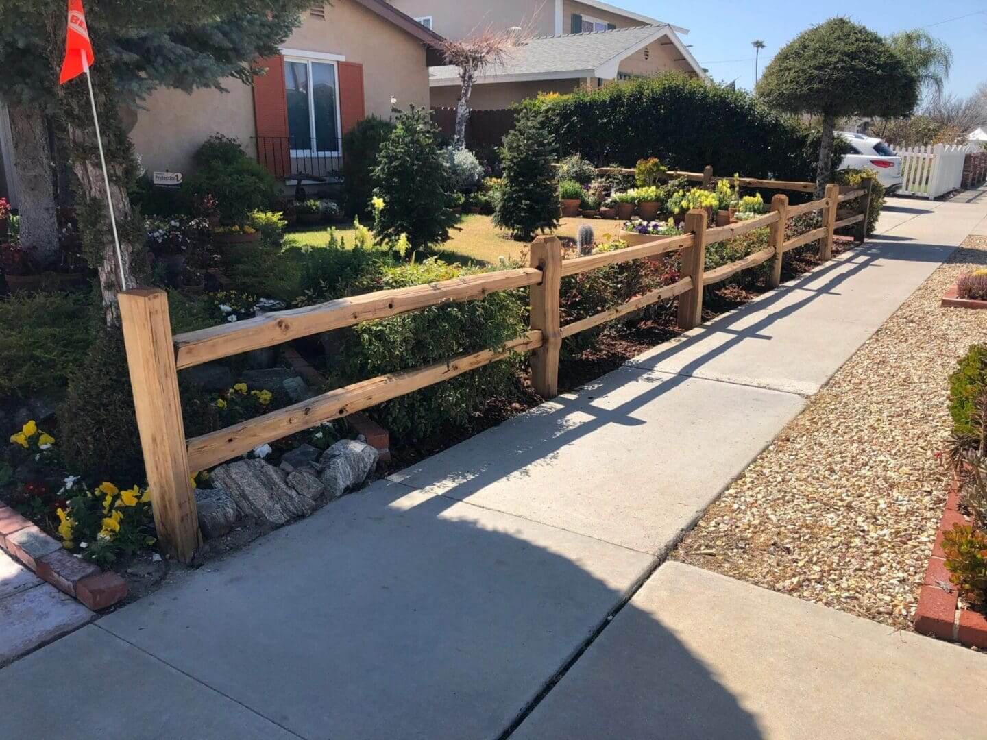 Garden pathway with wooden fence and flowers.