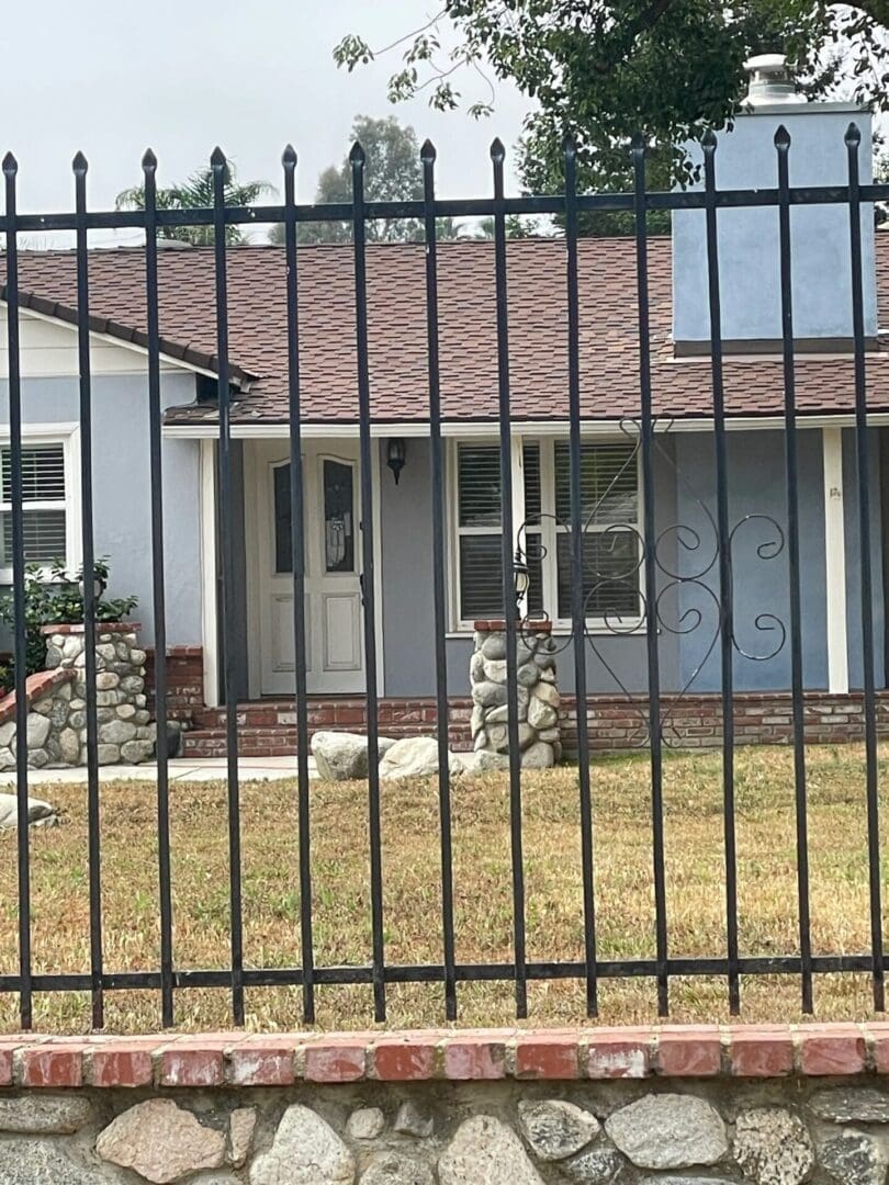 House behind black metal fence.