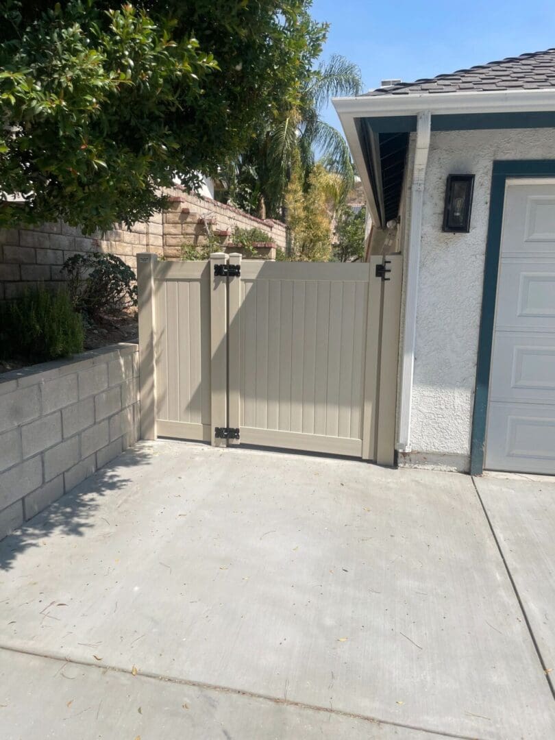 Wooden gate beside house on driveway.