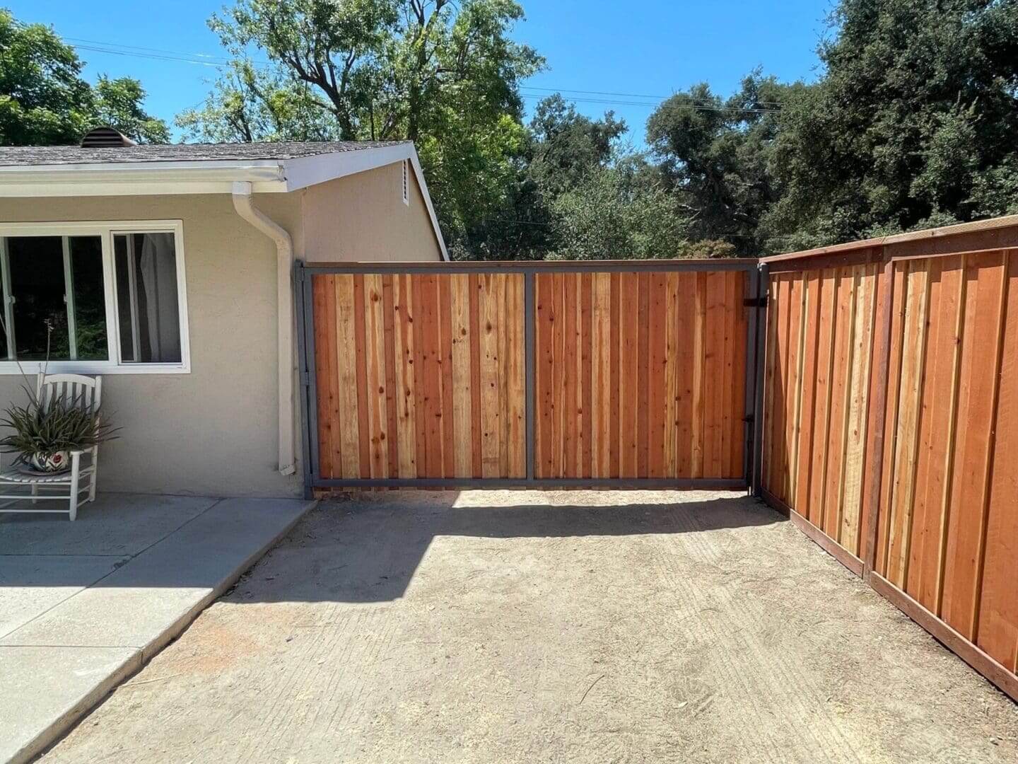 Wooden fence beside house with patio chair.
