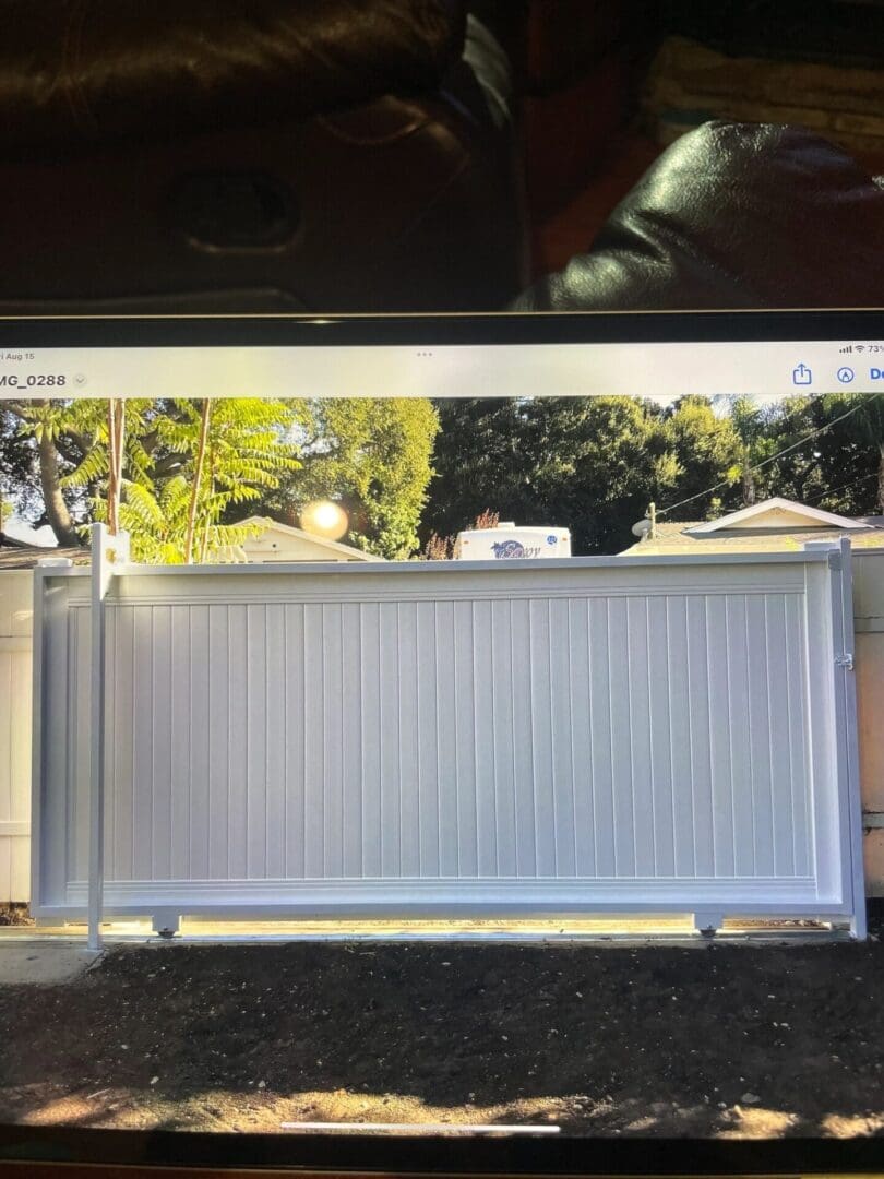 Sliding white gate in residential area.